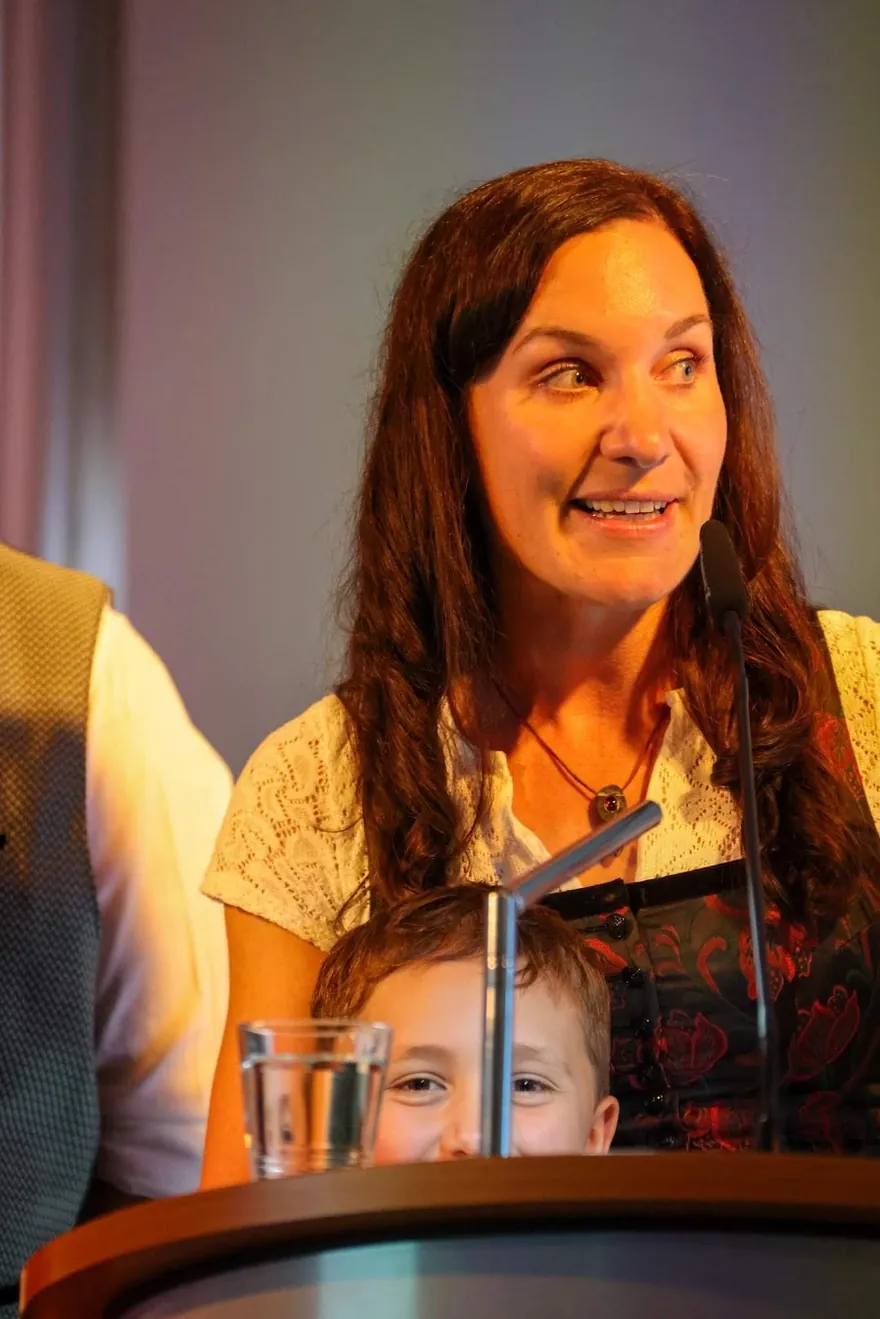Balbina Fuchs bei ihrer Dankesrede zum Wirtschaftspreis 2024, ihr Sohn steht mit ihr am Rednerpult