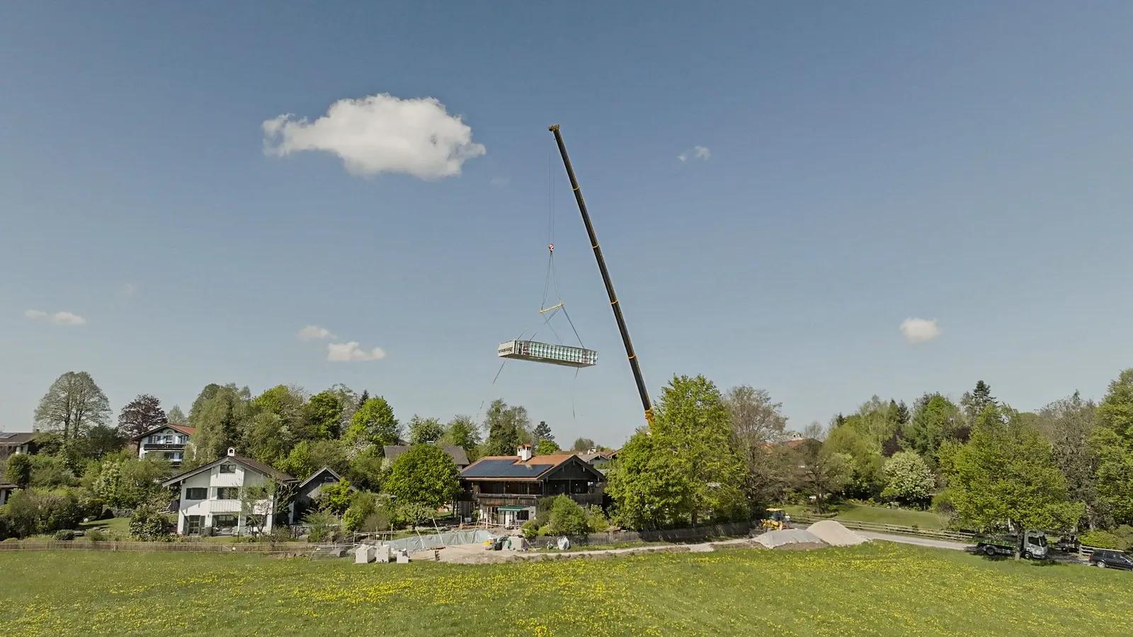 Fertigbecken hängt am Kranhaken vor blauem Himmel