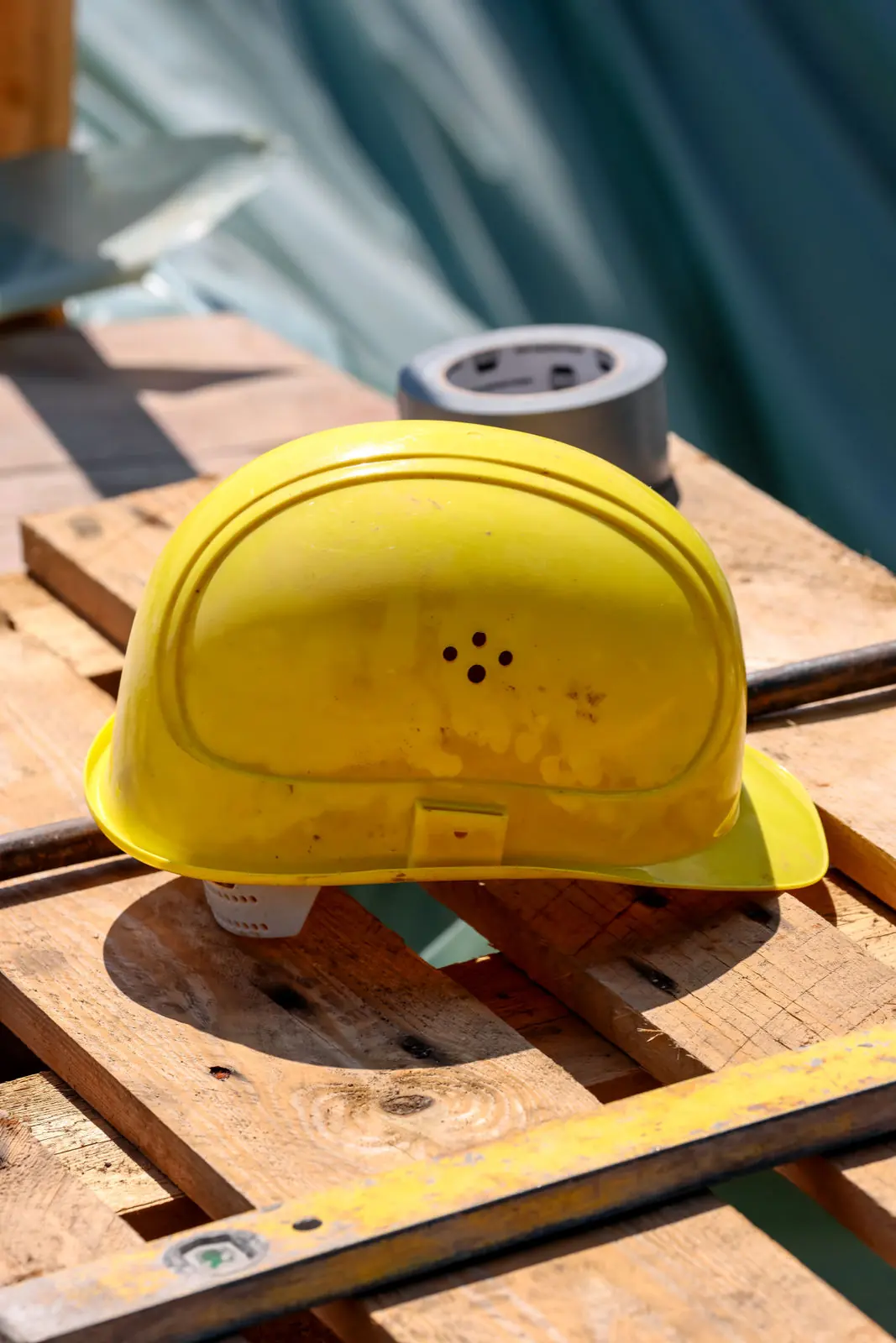 Bauhelm auf einer Palette am Rand der Baustelle