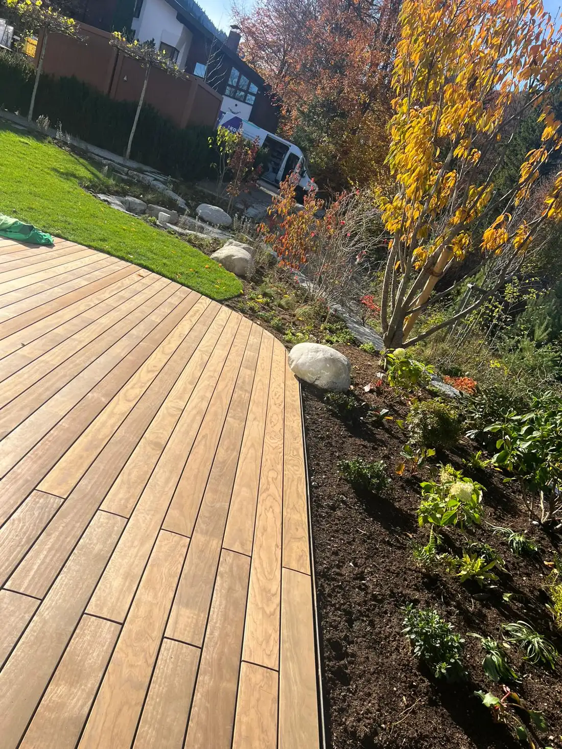 Geschwungenes Holzdeck, sauber an den Rasen angearbeitet