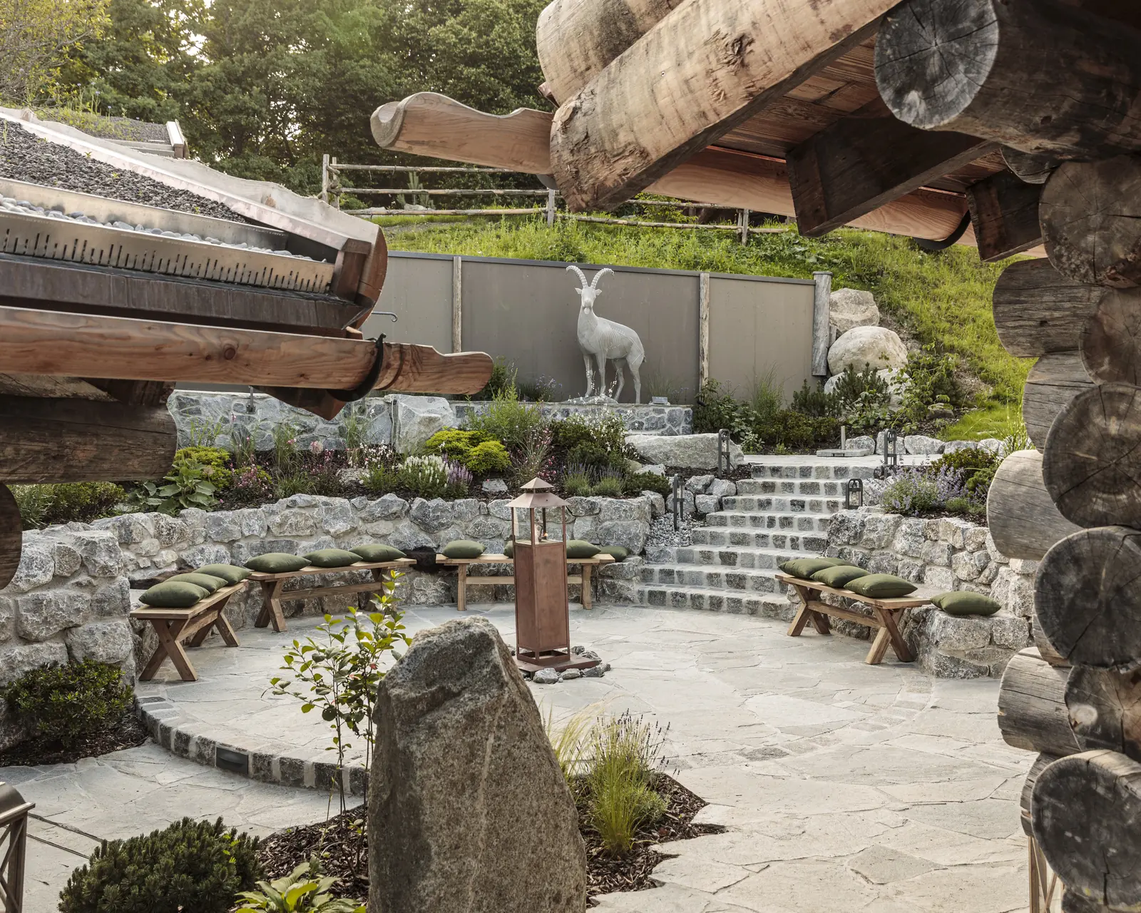 Saunahof im Alpenhof Murnau mit Natursteinmauern, Blockhäusern und Polygonalplatten aus Quarzit