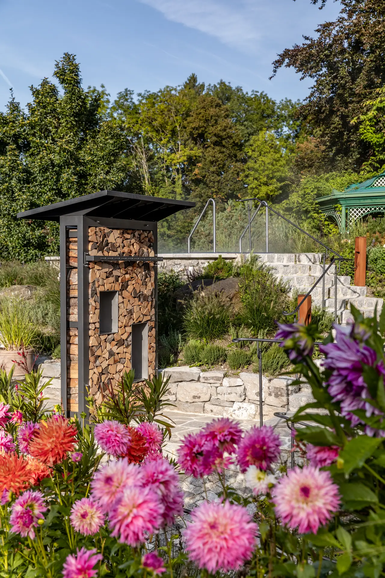 Dahlien in Rosa und Violett vor der Holzsäulen-Leuchte