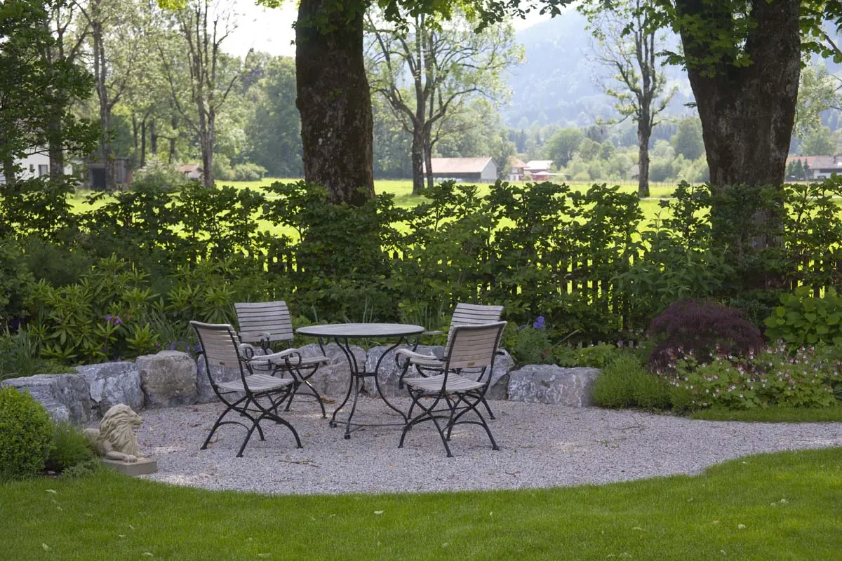 Sitzplatz aus Kies unter den alten Bäumen