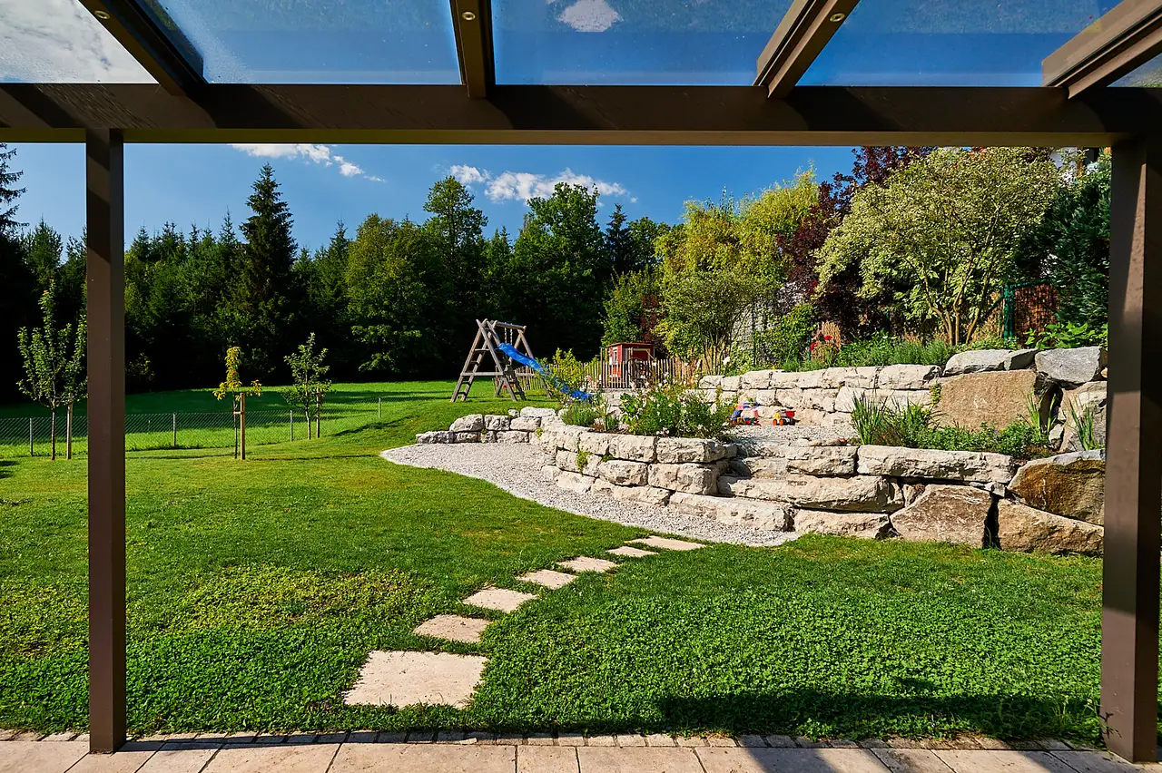 Durch die Pergola hindurch über den Rasen zum Spielbereich