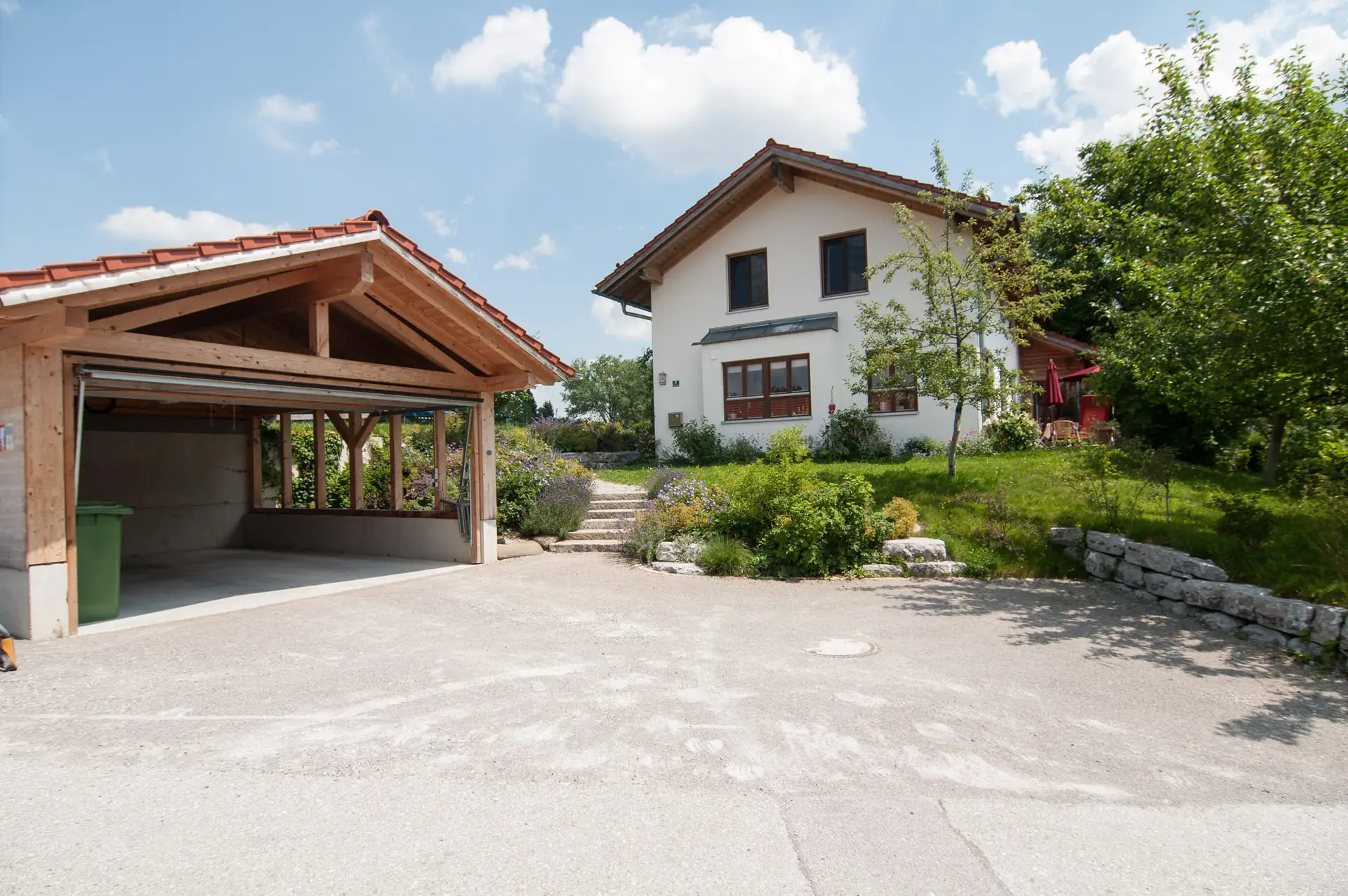 Die Zufahrt mit dem Unterstand, dahinter das Wohnhaus