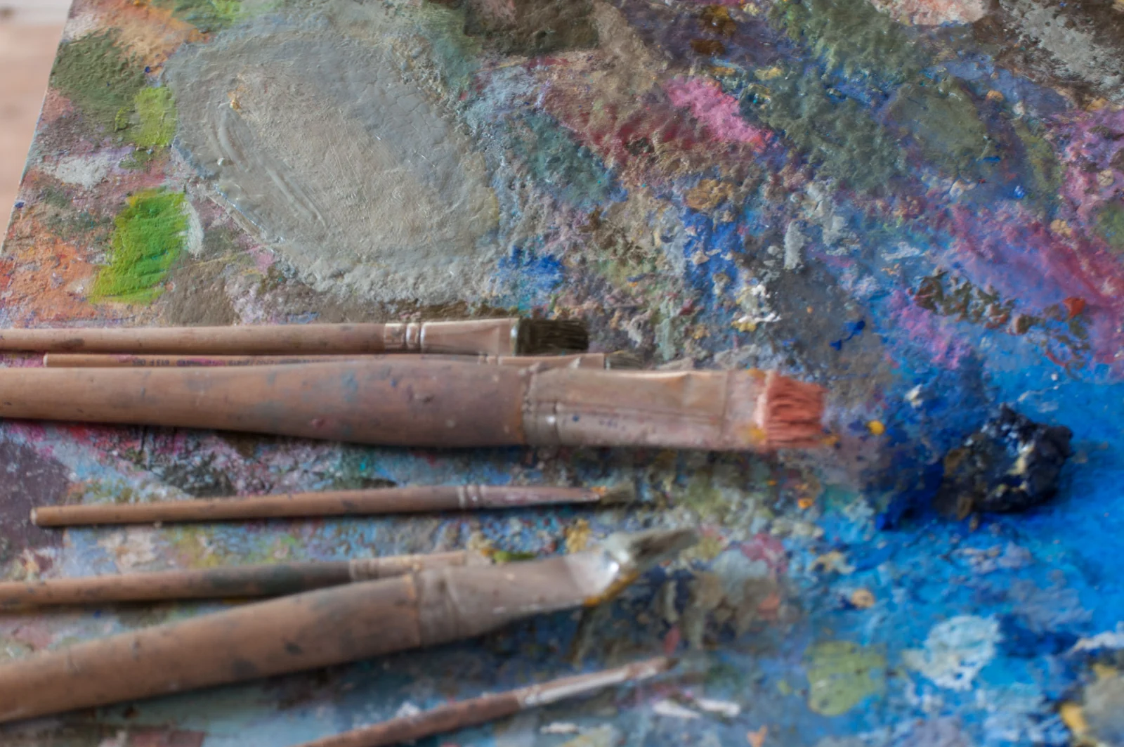 Pinselstiele mit angetrockneter Farbe, blau und ocker