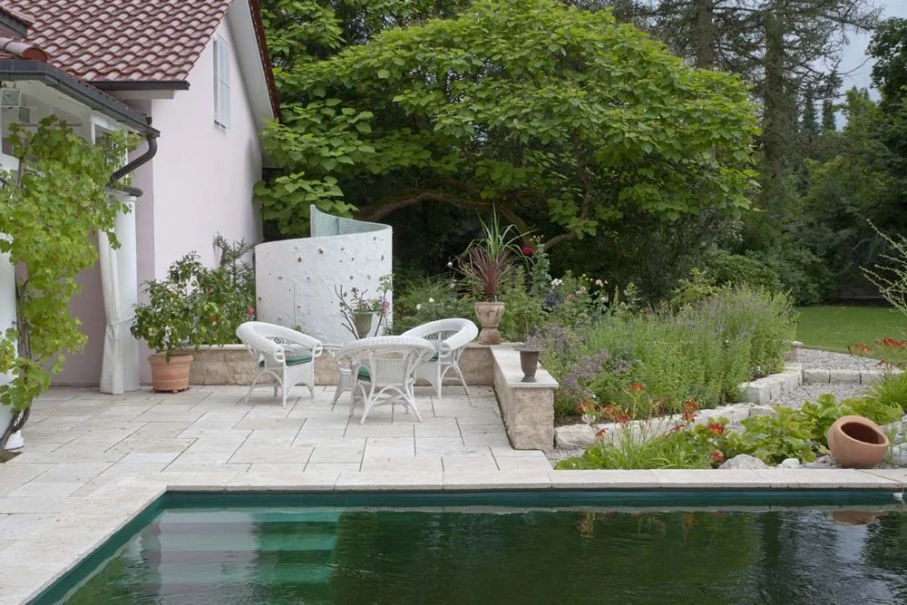 Blick über den Schwimmteich zur Terrasse mit Außendusche