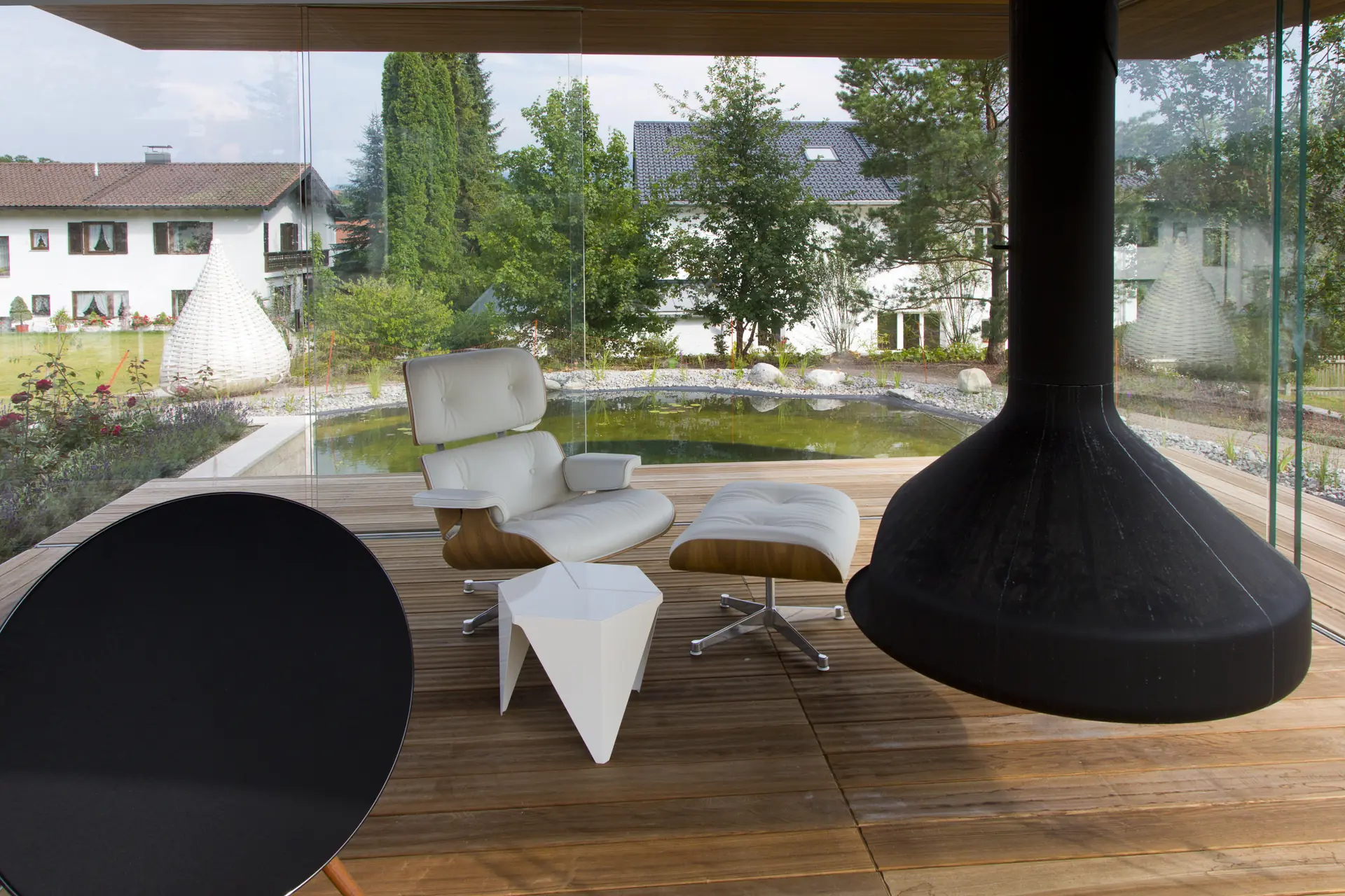 Blick in den Pavillon: der abgehängte offene Kamin über dem Holzboden