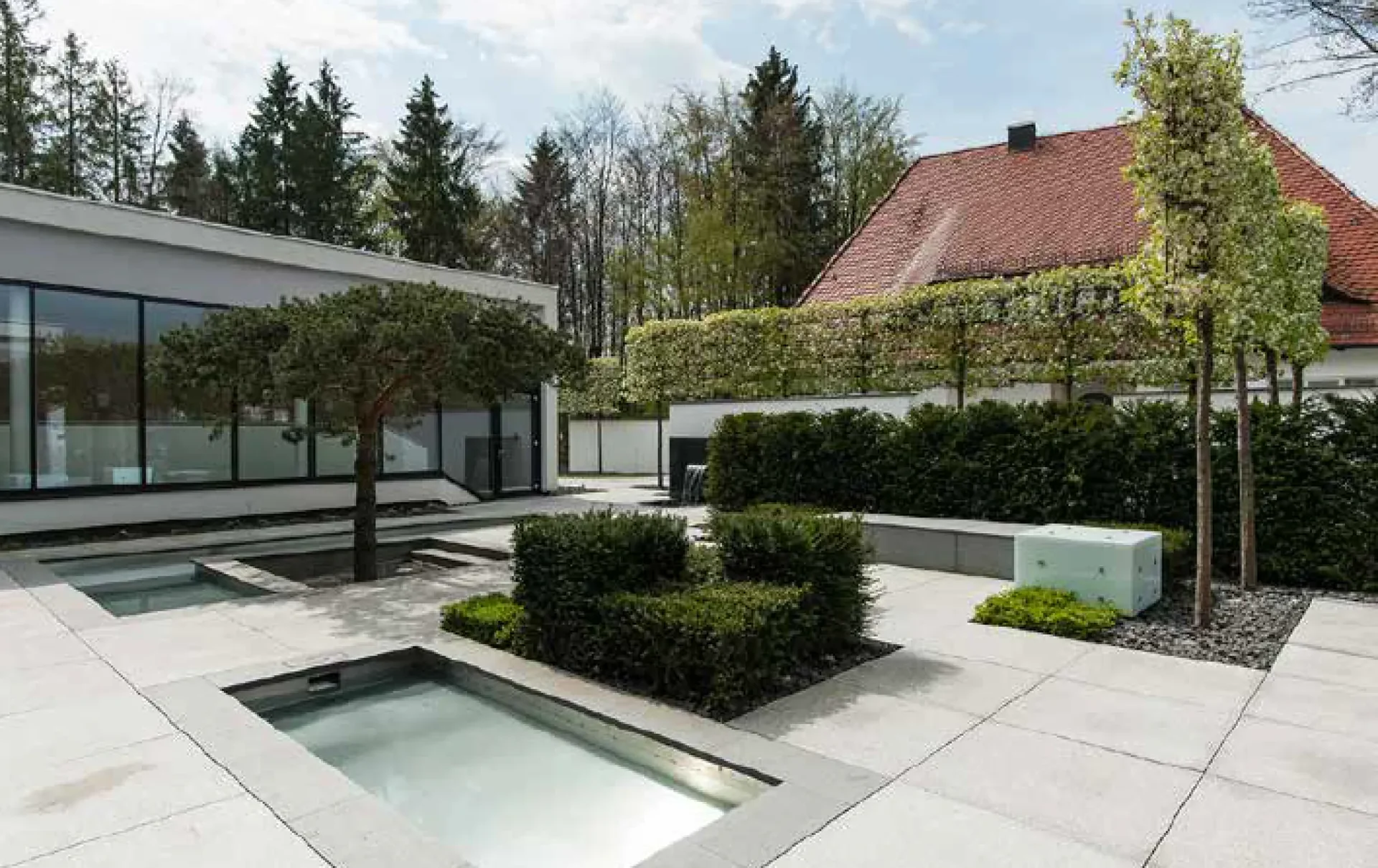 Der Innenhof mit den Wasserbecken, Granitplatten im Meterraster und Sitzwürfeln