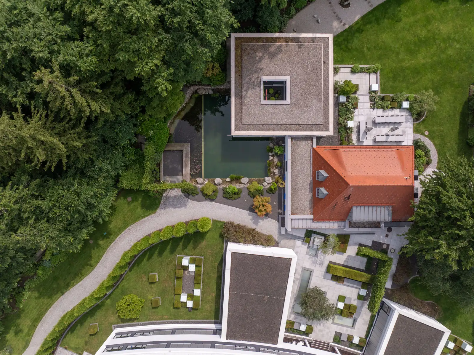Senkrecht von oben – die flachen Dächer, der Schwimmteich und die Innenhöfe mit ihren quadratischen Pflanzbeeten