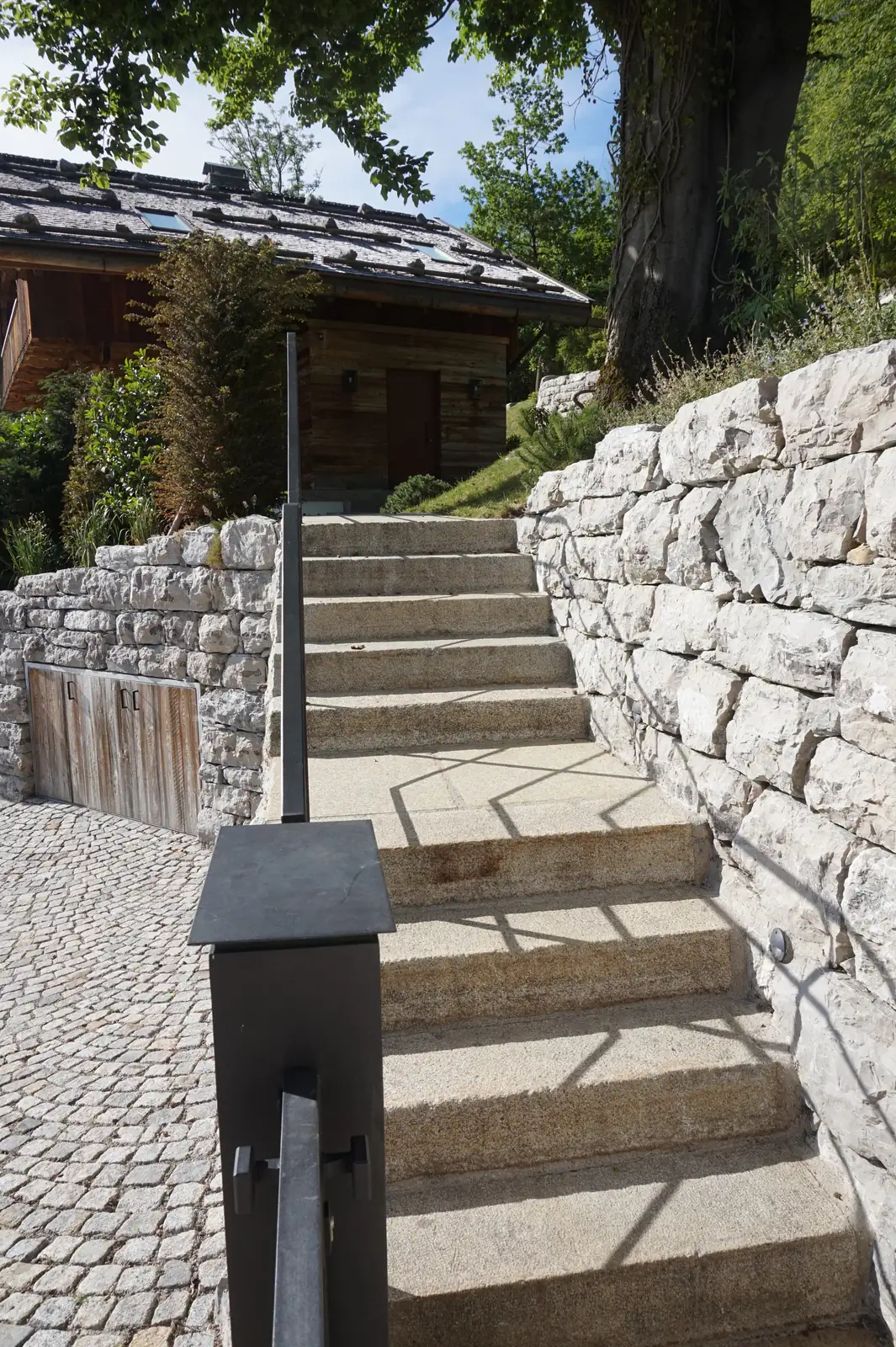 Die Treppe steigt an der Kalksteinmauer den Hang hinauf