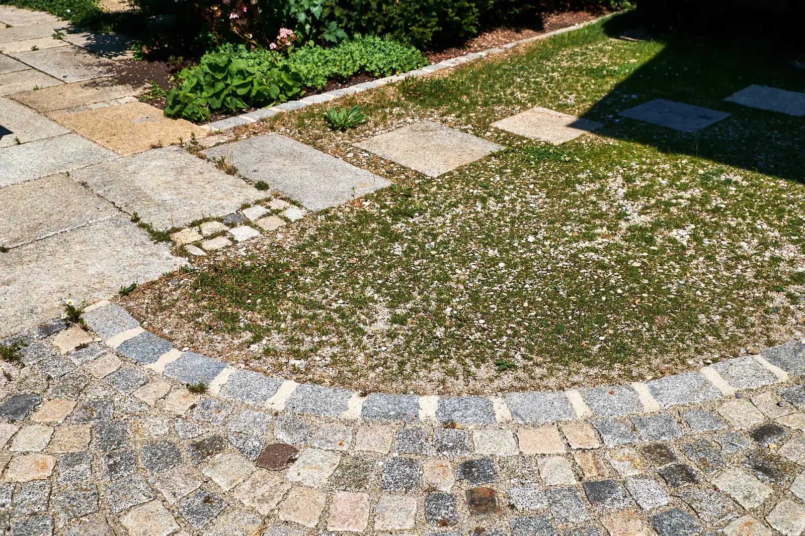 Der Pflasterbogen fasst den Blumen-Schotterrasen