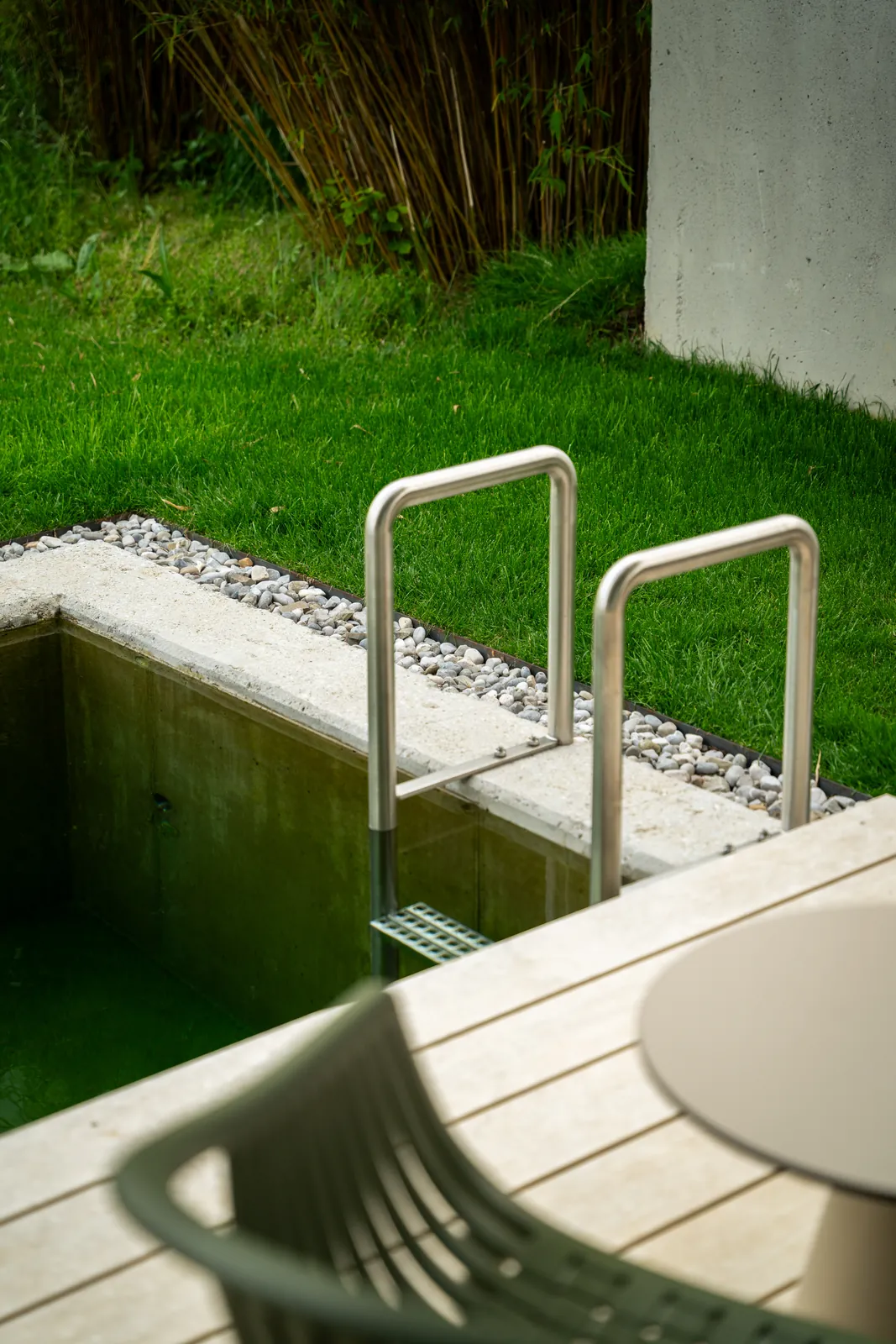 Licht fällt durch das Deckenauge auf das Tauchbecken aus Sichtbeton