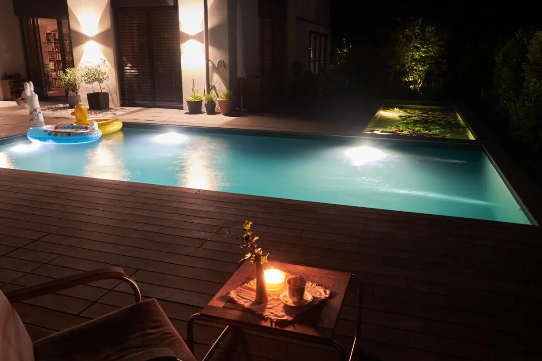 Kerzen und Feuerschale auf dem Deck, das Wasser spiegelt das Licht