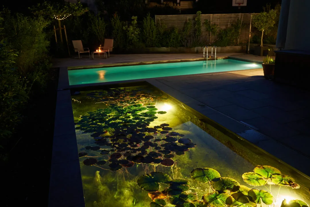 Pool und Seerosenbecken nebeneinander, beide beleuchtet