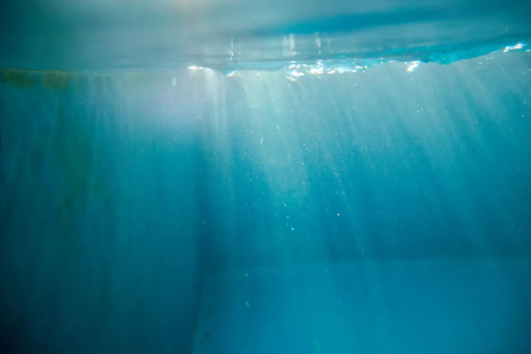 Lichtstrahlen fallen durchs türkise Wasser