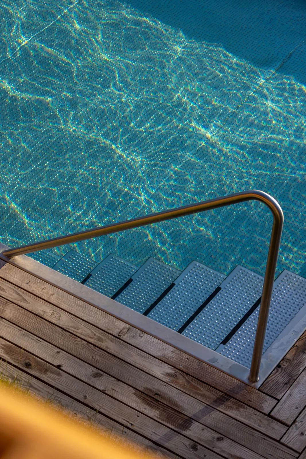 Die Edelstahlleiter im türkisen Wasser