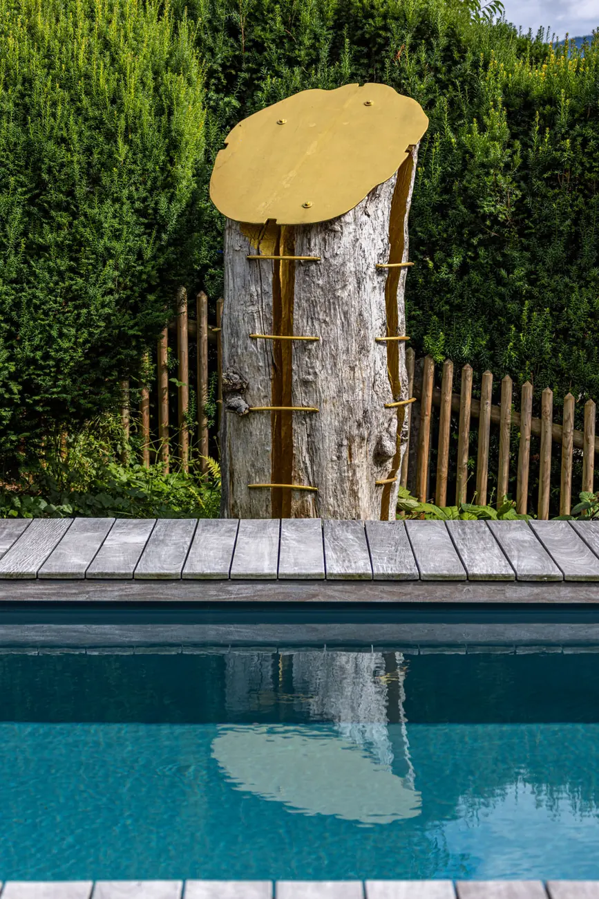 Eine Holzskulptur am Beckenrand