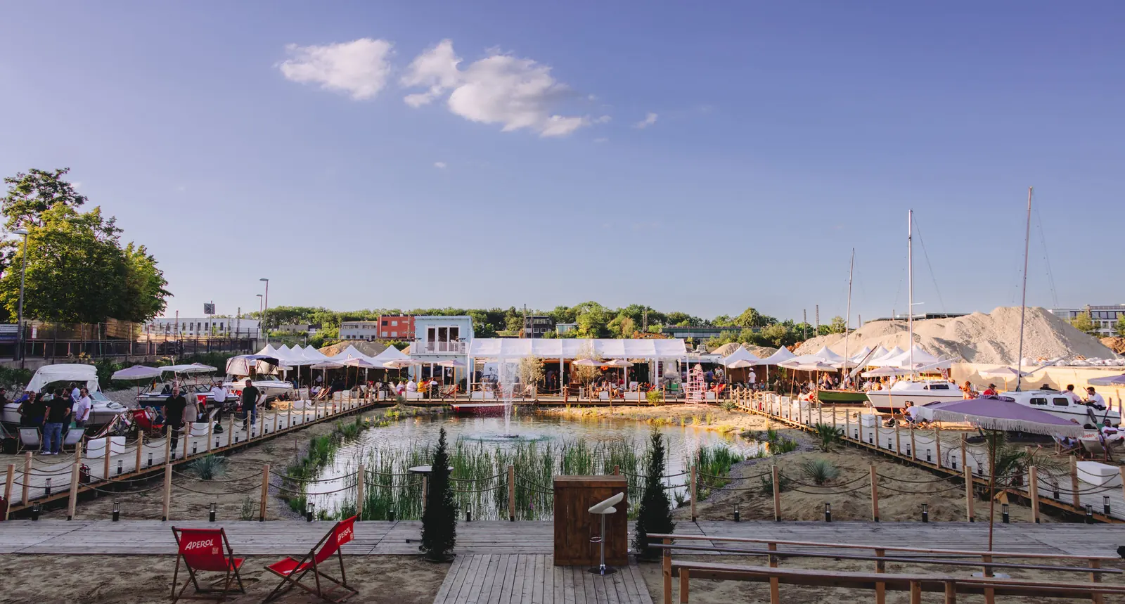 Abendlicht über Teich, Liegestühlen und Strandbar