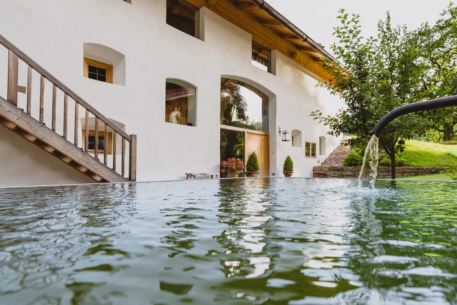 Das Wasserbecken mit Speier an der Treppe zum Haus