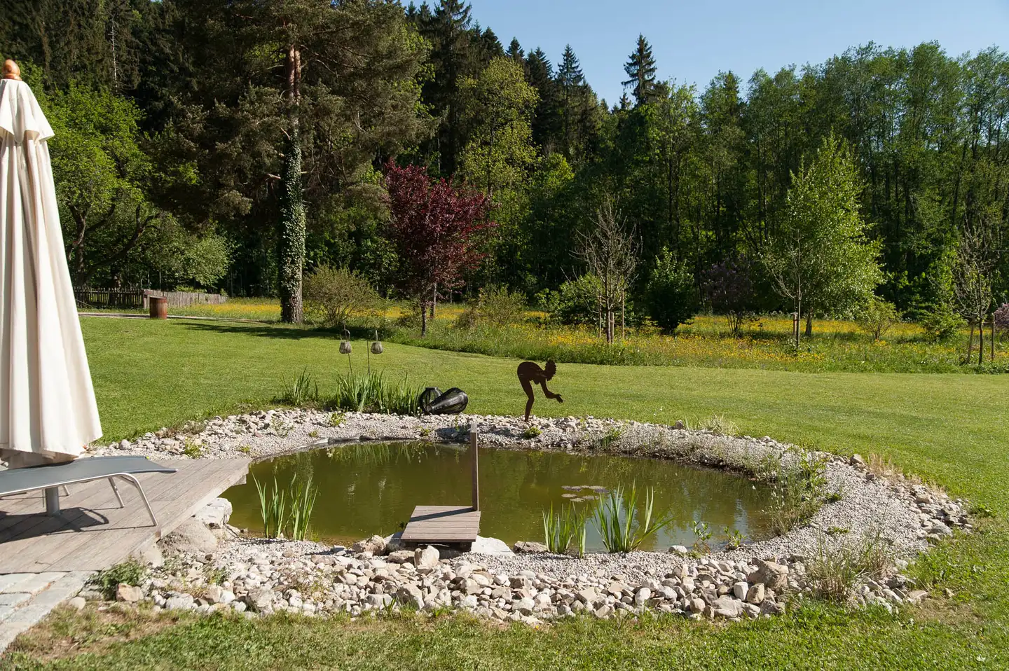 Der Naturteich mit Kiesufer in der Wiese