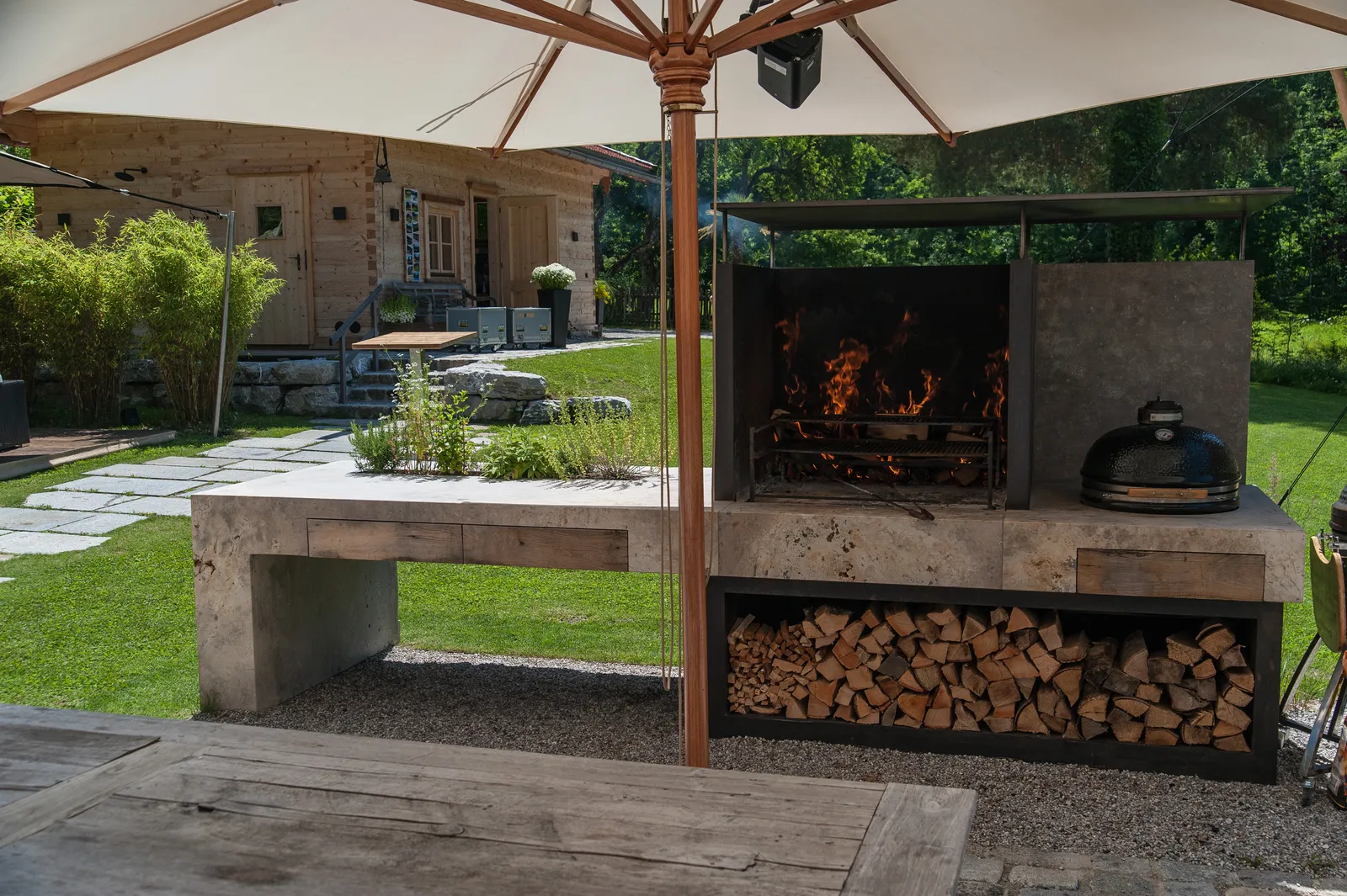 Die Außenküche mit gemauertem Kamin und Holzlager darunter