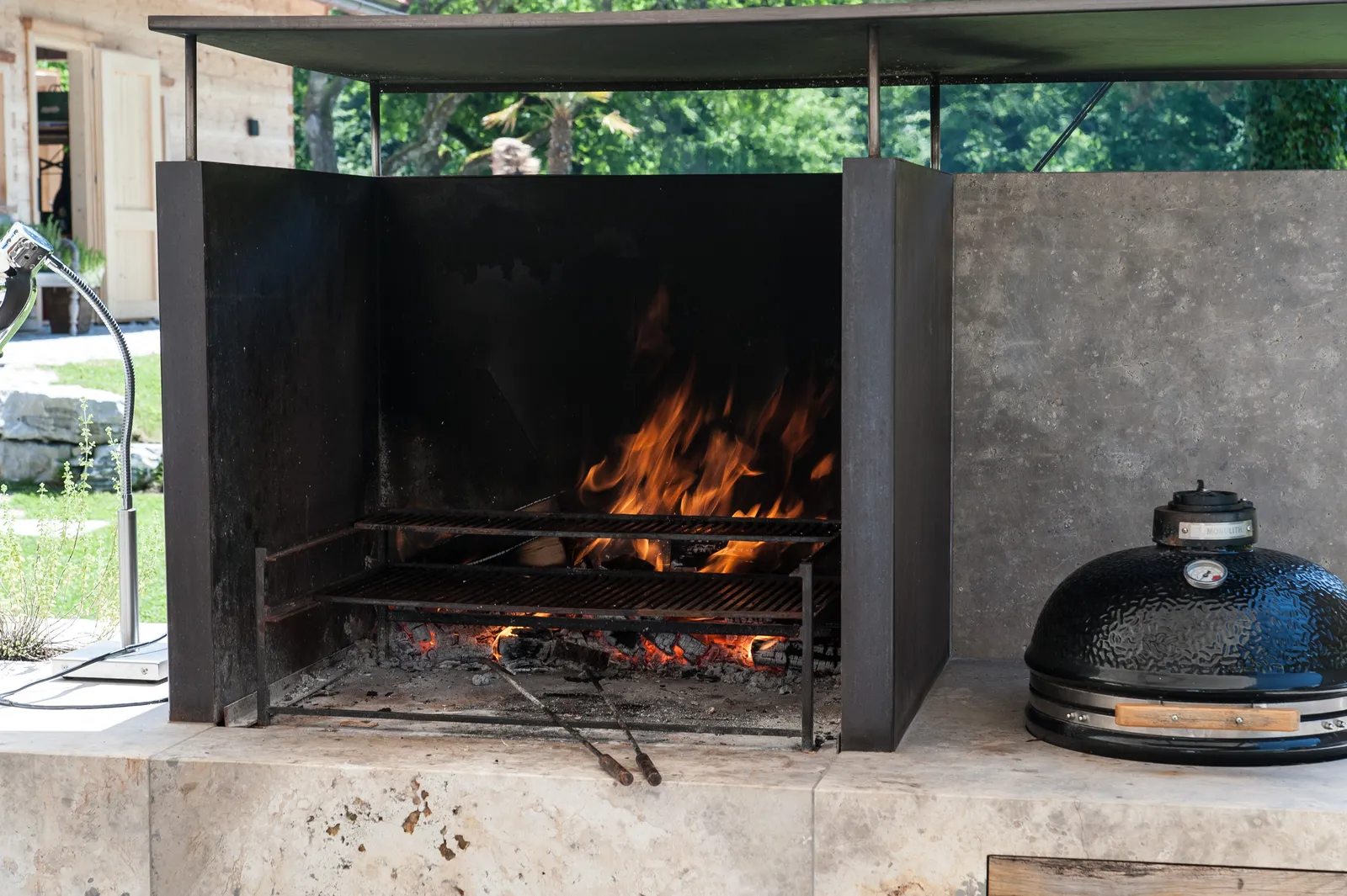 Feuer im Kamin, daneben ein Keramikgrill