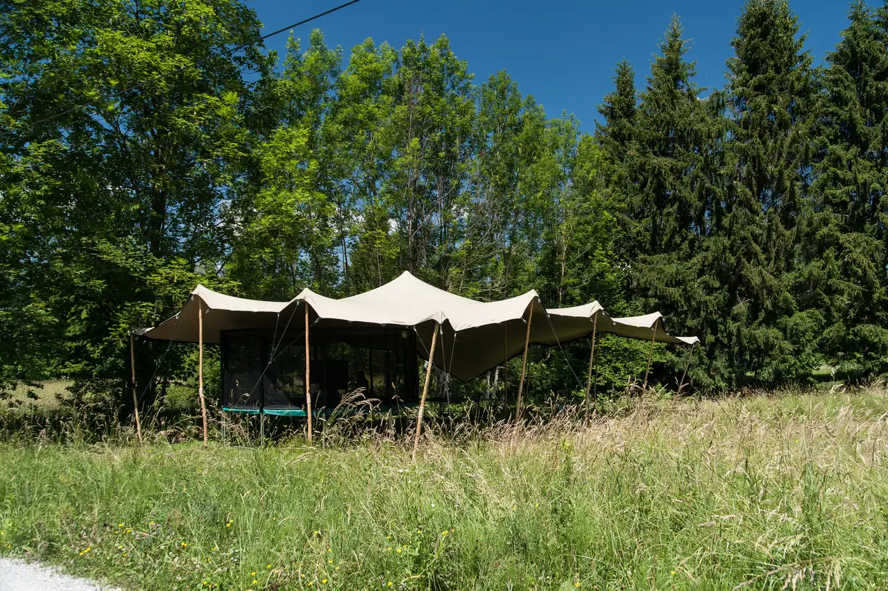 Über die hohe Wiese hinweg zu den Segeln und dem Haus