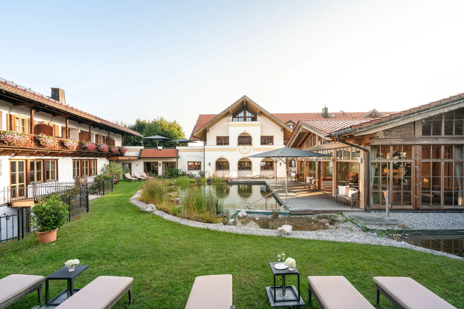 Der Teich liegt mitten im Innenhof des Posthotels, die Liegen warten auf der Wiese