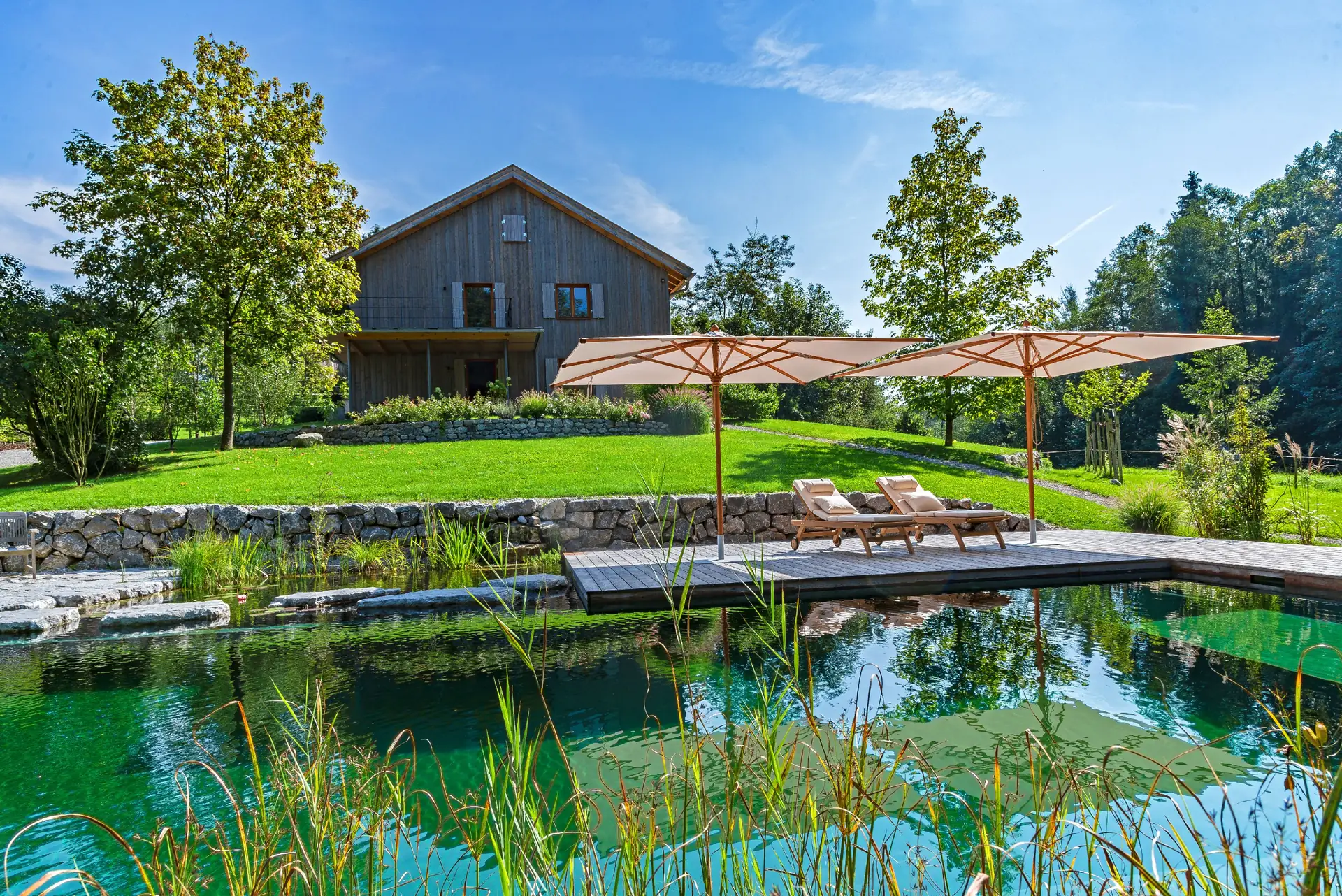 Das Haus über dem Teich, im Vordergrund die Gräser der Regenerationszone
