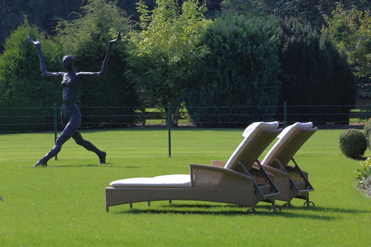 Liegen auf dem weiten Rasen, hinten grüßt die Skulptur
