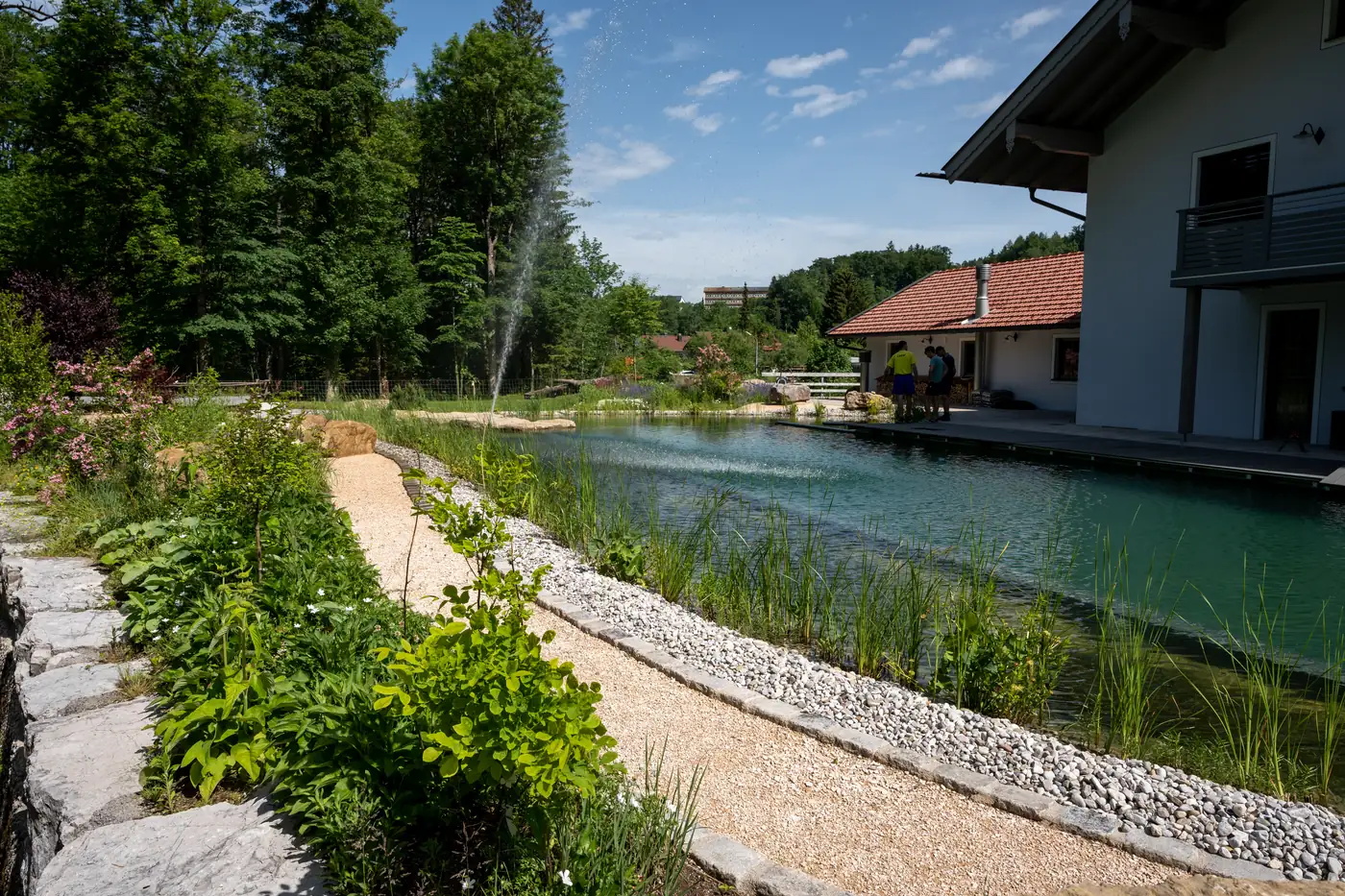 Der Weg begleitet den Teich am Hang entlang