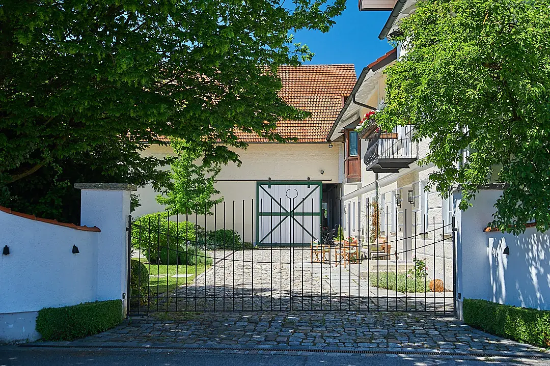 Die neue Toranlage: schmiedeeisernes Hoftor in der verputzten Gartenmauer