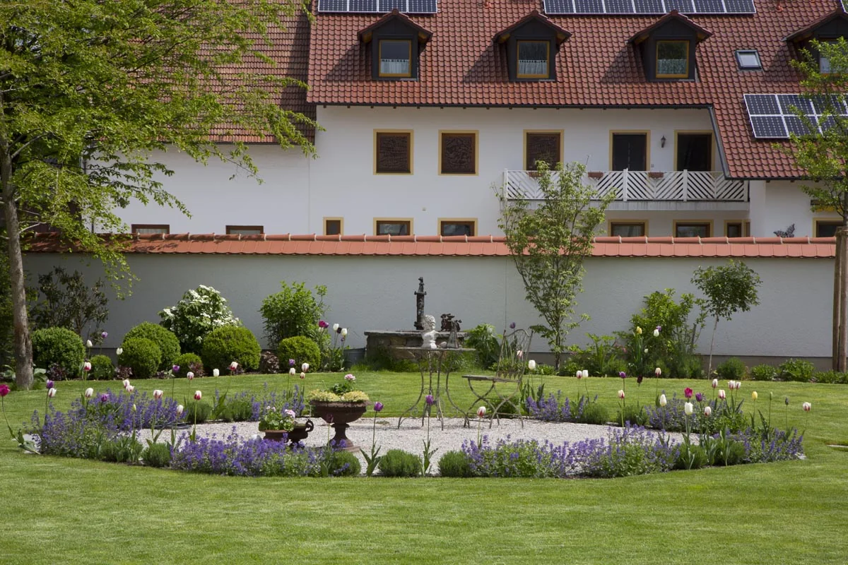 Der große Innenhof mit dem ovalen Kiesbeet und Lavendel