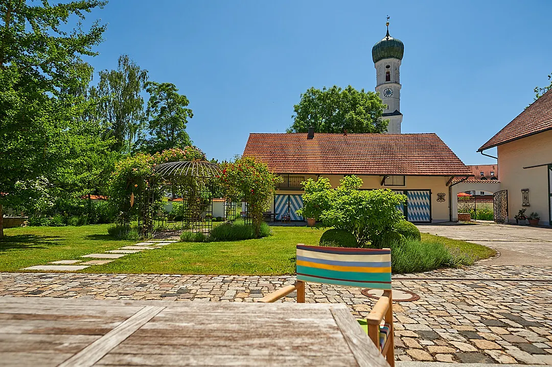 Blick über den Hof zur Bank, über den Dächern der Kirchturm