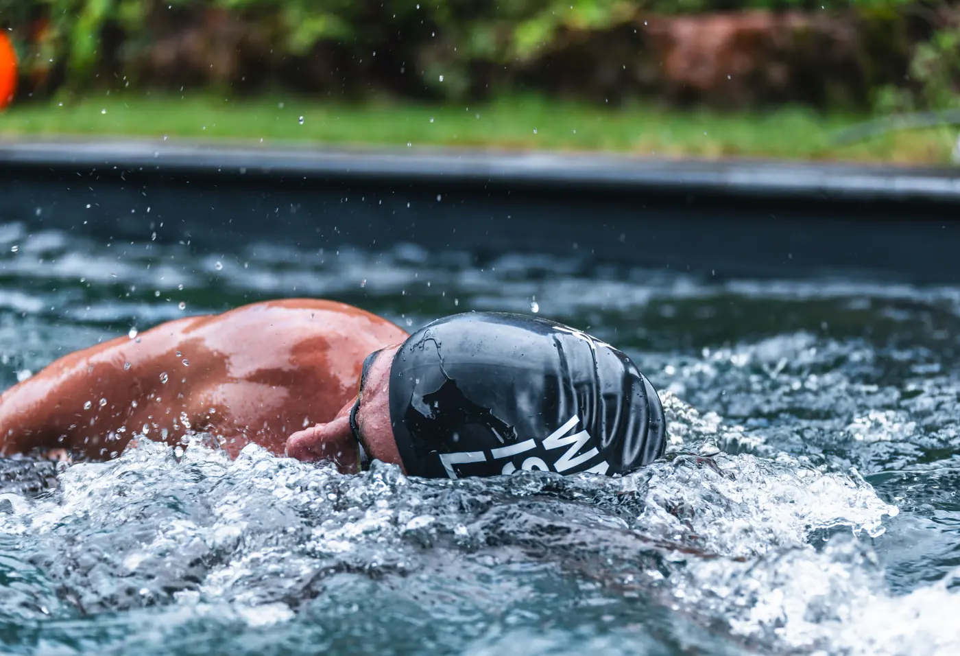 Ein Schwimmer schwimmt gegen die Strömung der Gegenstromanlage, das Wasser ist aufgewühlt