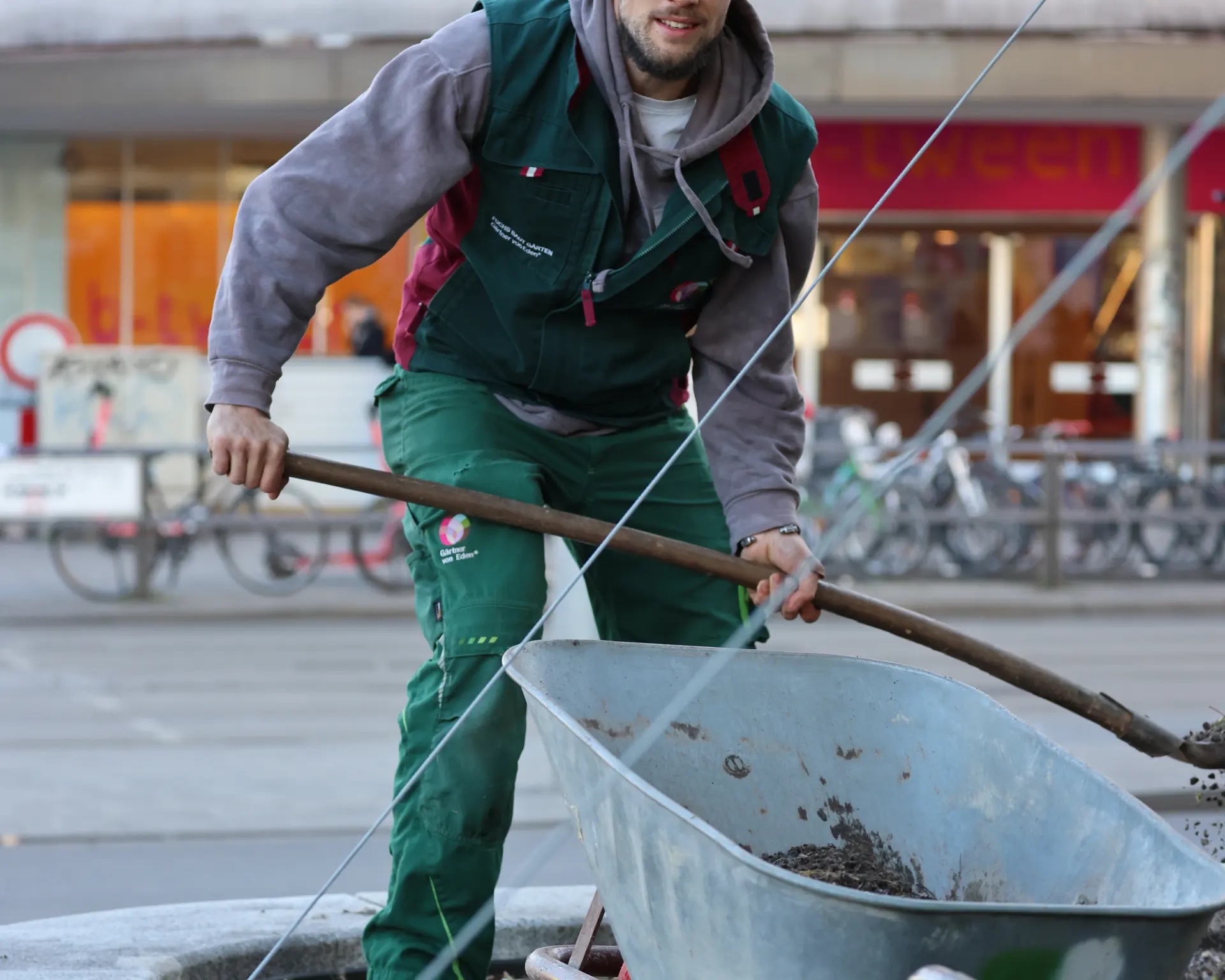 Landschaftsgärtner baut Pflanzsubstrat in ein Pflanzbeet in der Stadt ein