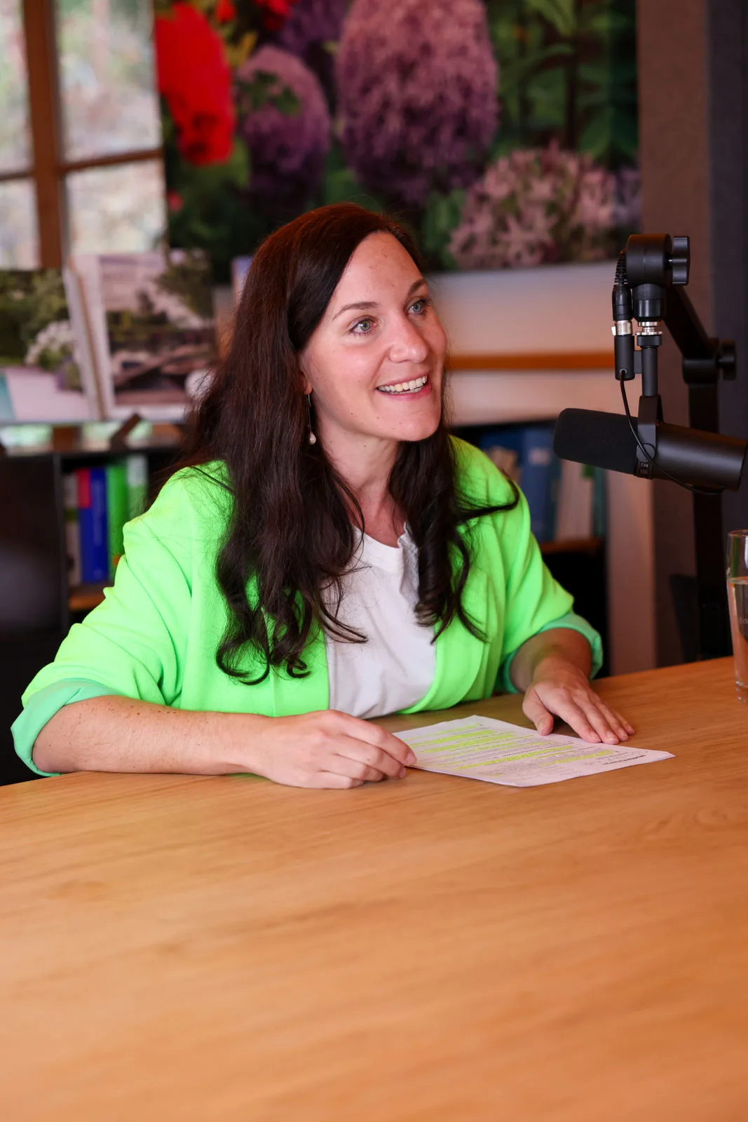 Balbina Fuchs im grünen Blazer am Mikrofon des Fuchs baut Podcasts
