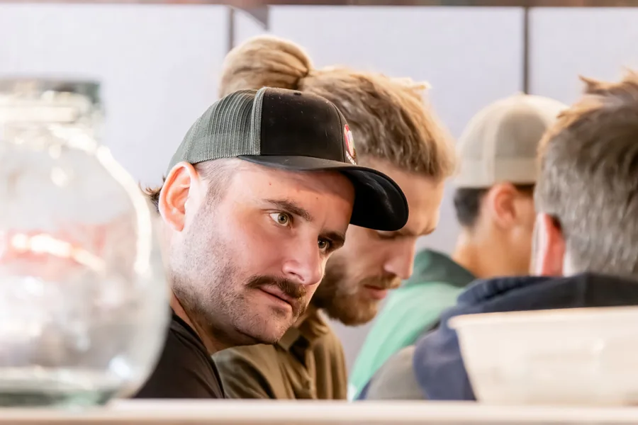 Zwei Kollegen mit Kappen hören konzentriert zu