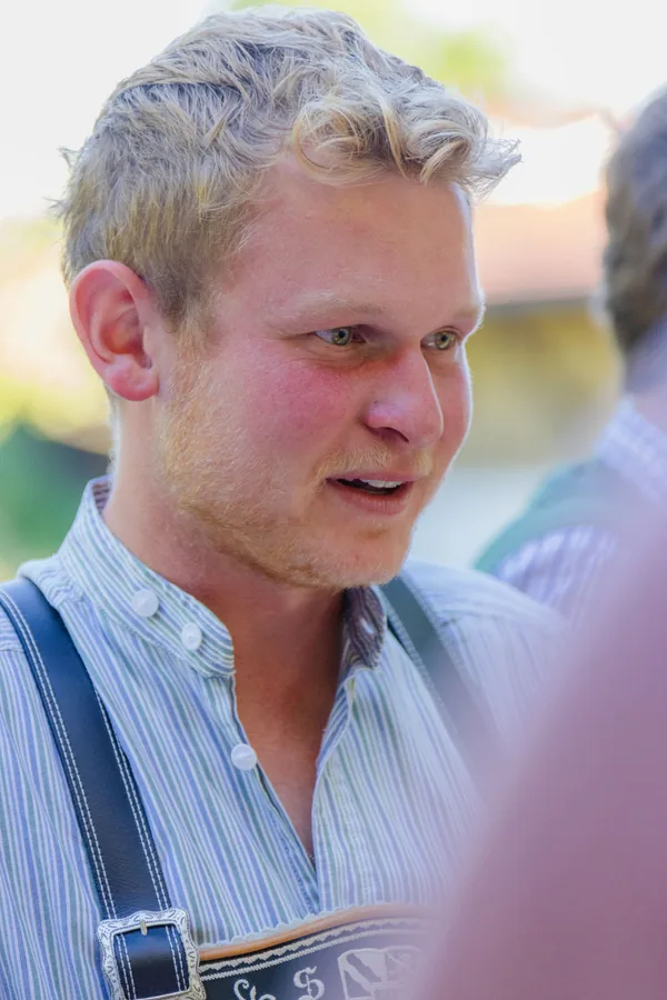 Kollege in Lederhosen im Gespräch am Abend