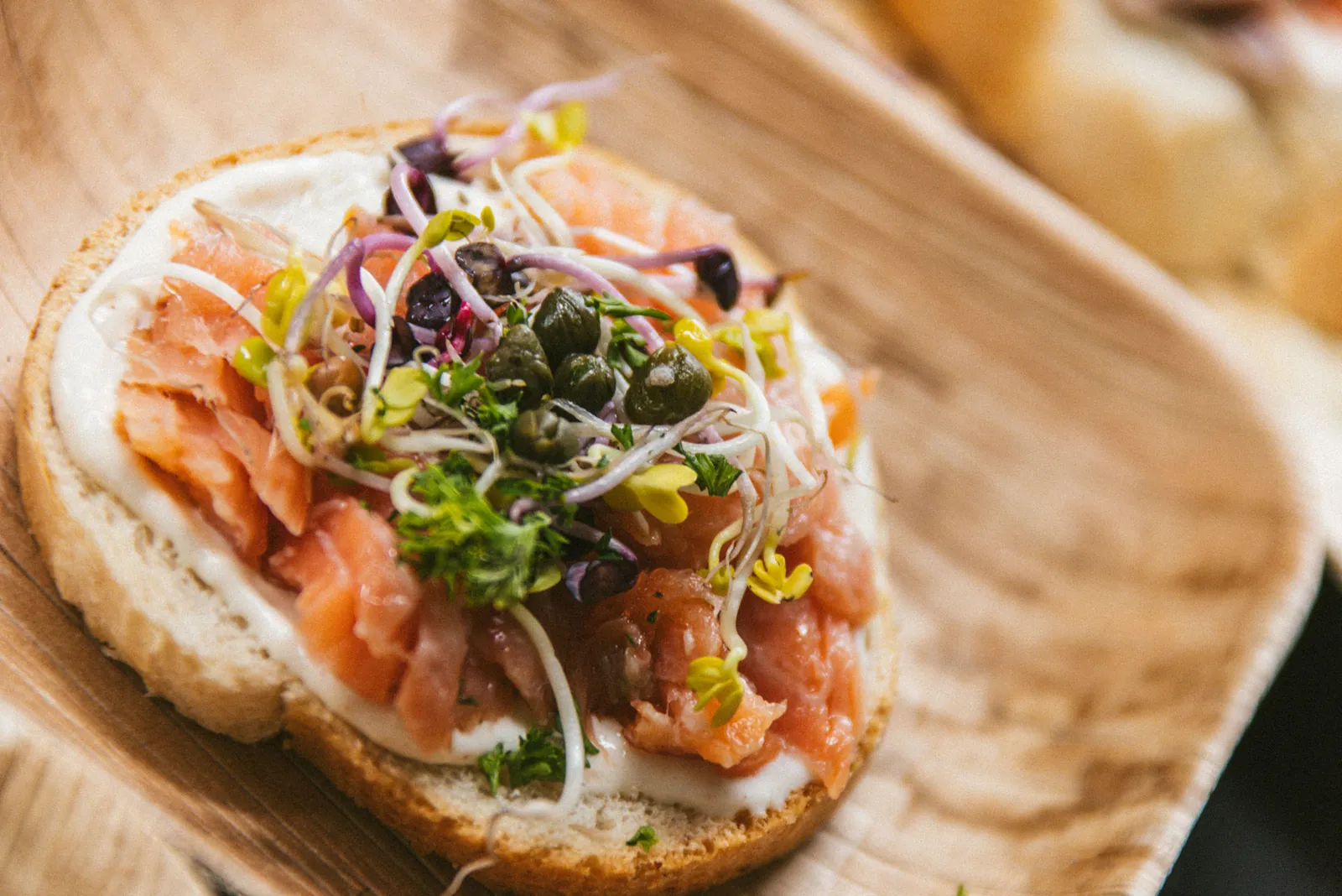 Häppchen mit Lachs und Sprossen auf dem Holzteller