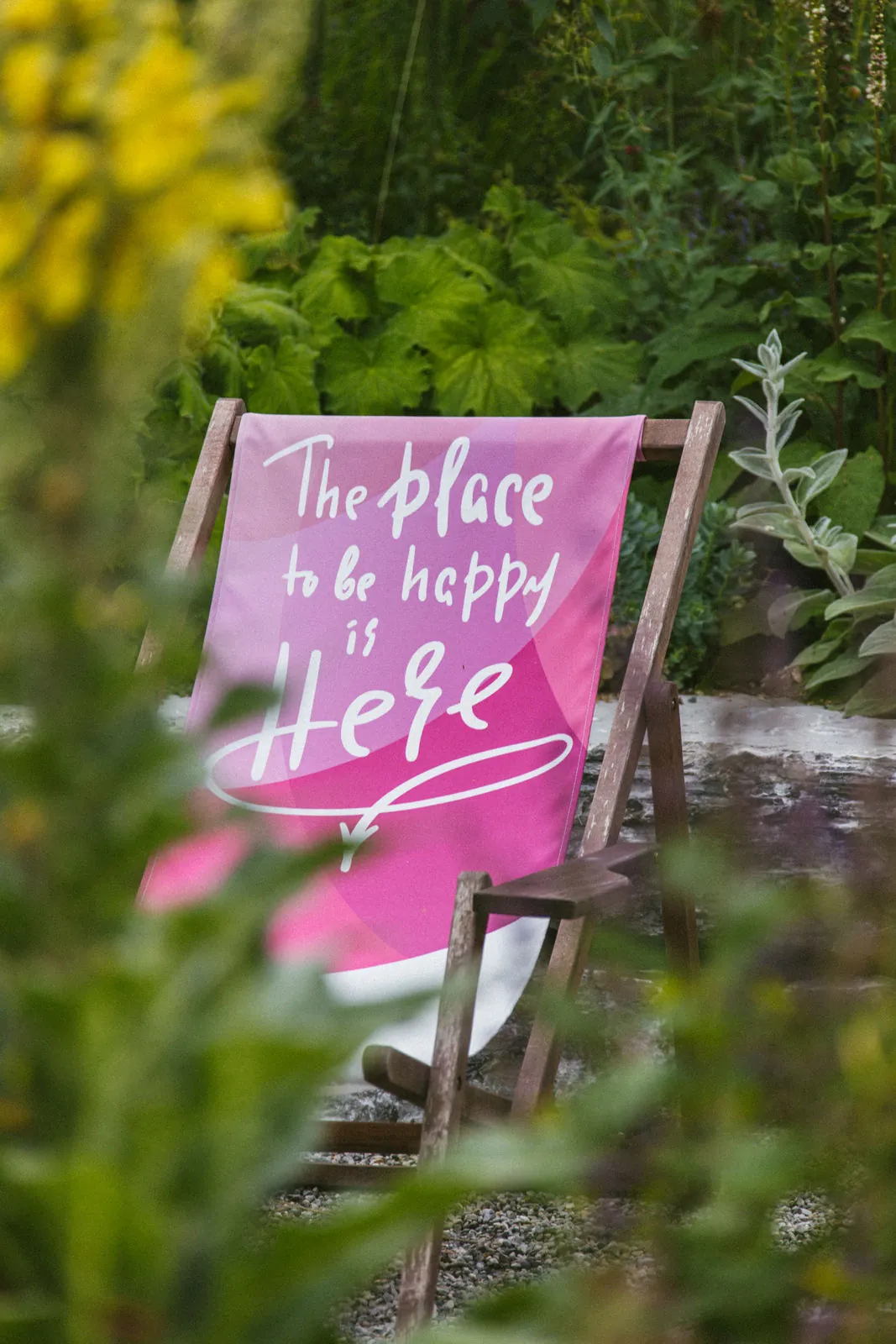 Pinker Liegestuhl zwischen Königskerzen: „The place to be happy is here“