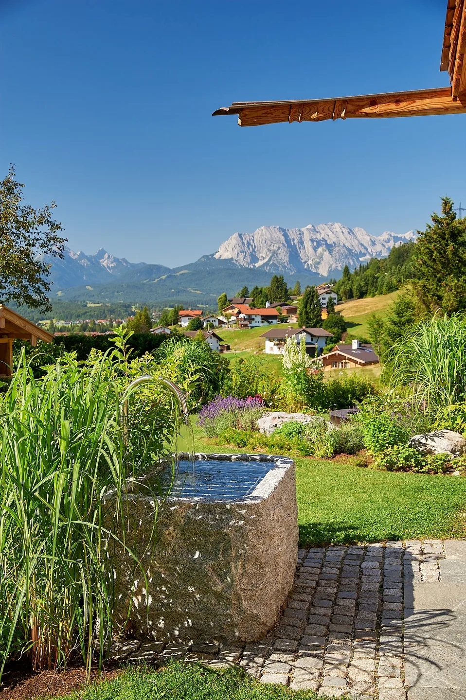 Brunnen aus einem Granitblock mit Blick auf die Berge