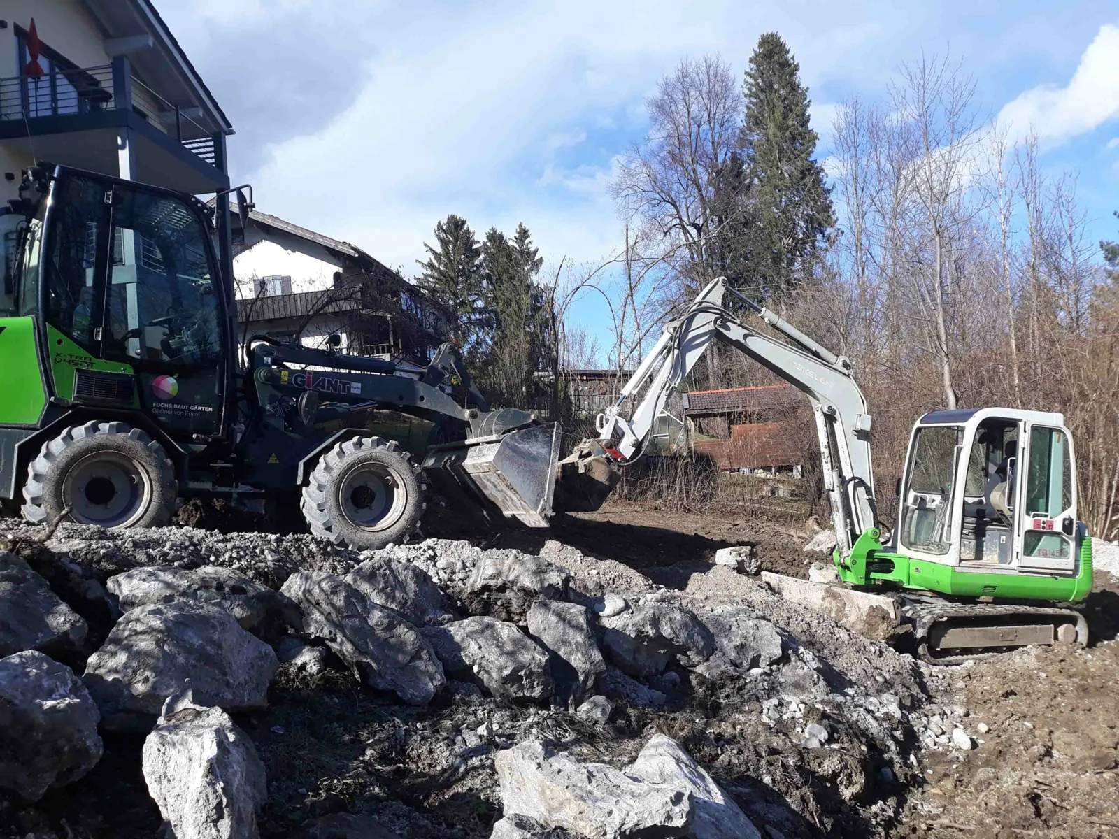 Bagger setzt Granitfindlinge auf einer unserer Baustellen