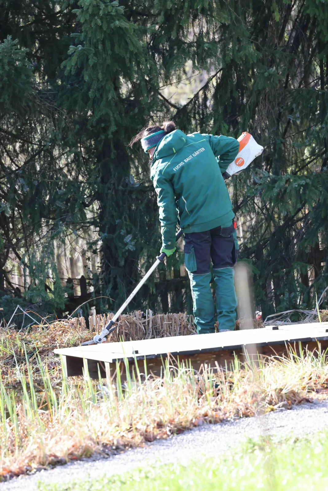 Kollege arbeitet die Rasenkante an einer Pflanzfläche nach
